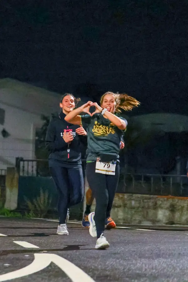 Atleta a fazer um coração com as mãos durante a prova.