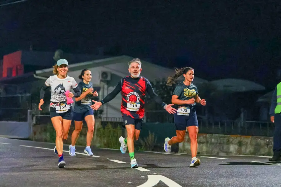 Grupo de quatro atletas a correr de noite.
